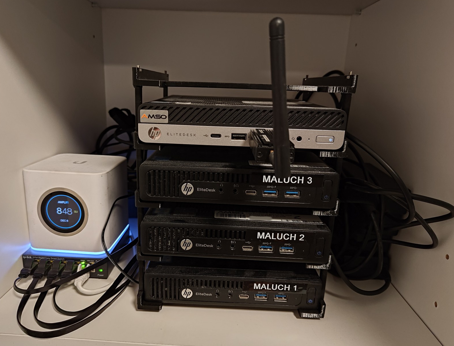 Stack on the shelf. Power cables are well-hidden behind but still messy.